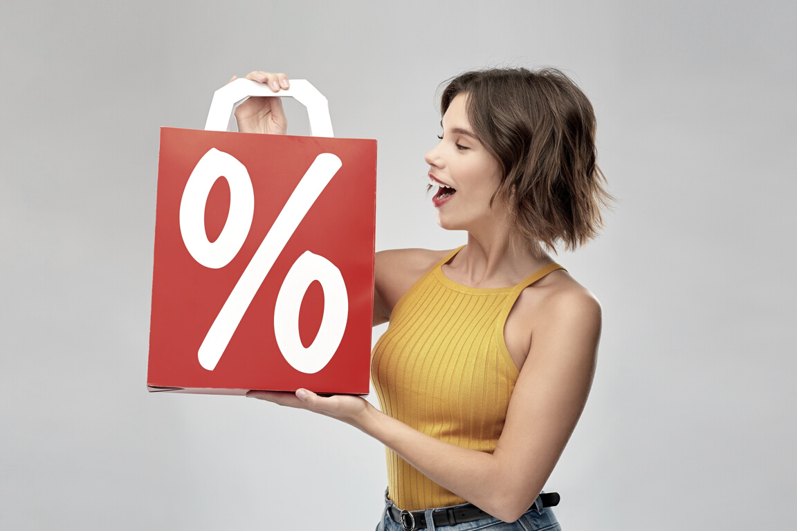 Happy Smiling Young Woman with Sale Signs